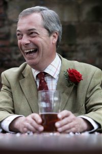 Nigel Farage med en øl mellom hendene. Foto.