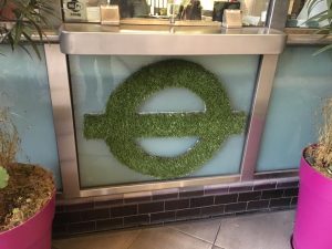 Logo laget av busk - stasjonen Clapham North, sør i London. Foto